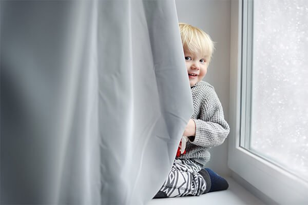 a baby with curtain cleaned by fresho cleaning services Qatar